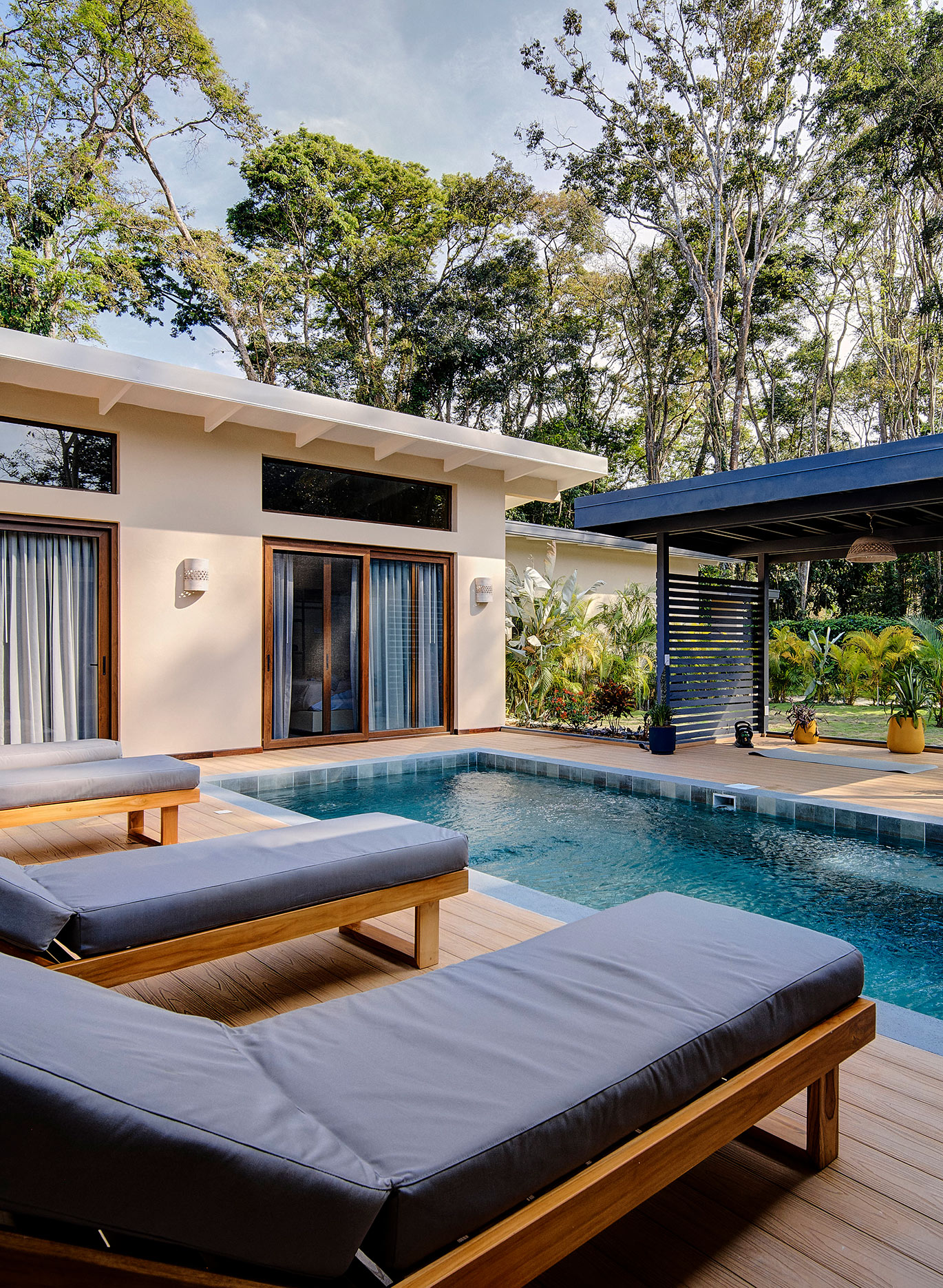 Piscina rodeada de vegetación con zona de relajación y espacio para yoga, meditación u otras actividades