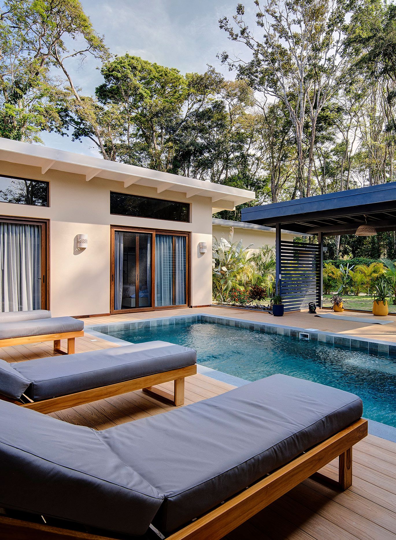Piscina rodeada de vegetaci&oacute;n con zona de relajaci&oacute;n y espacio para yoga, meditaci&oacute;n u otras actividades