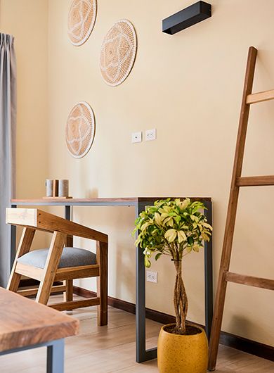 Escritorio de madera con una escalera y una planta decorativa al lado