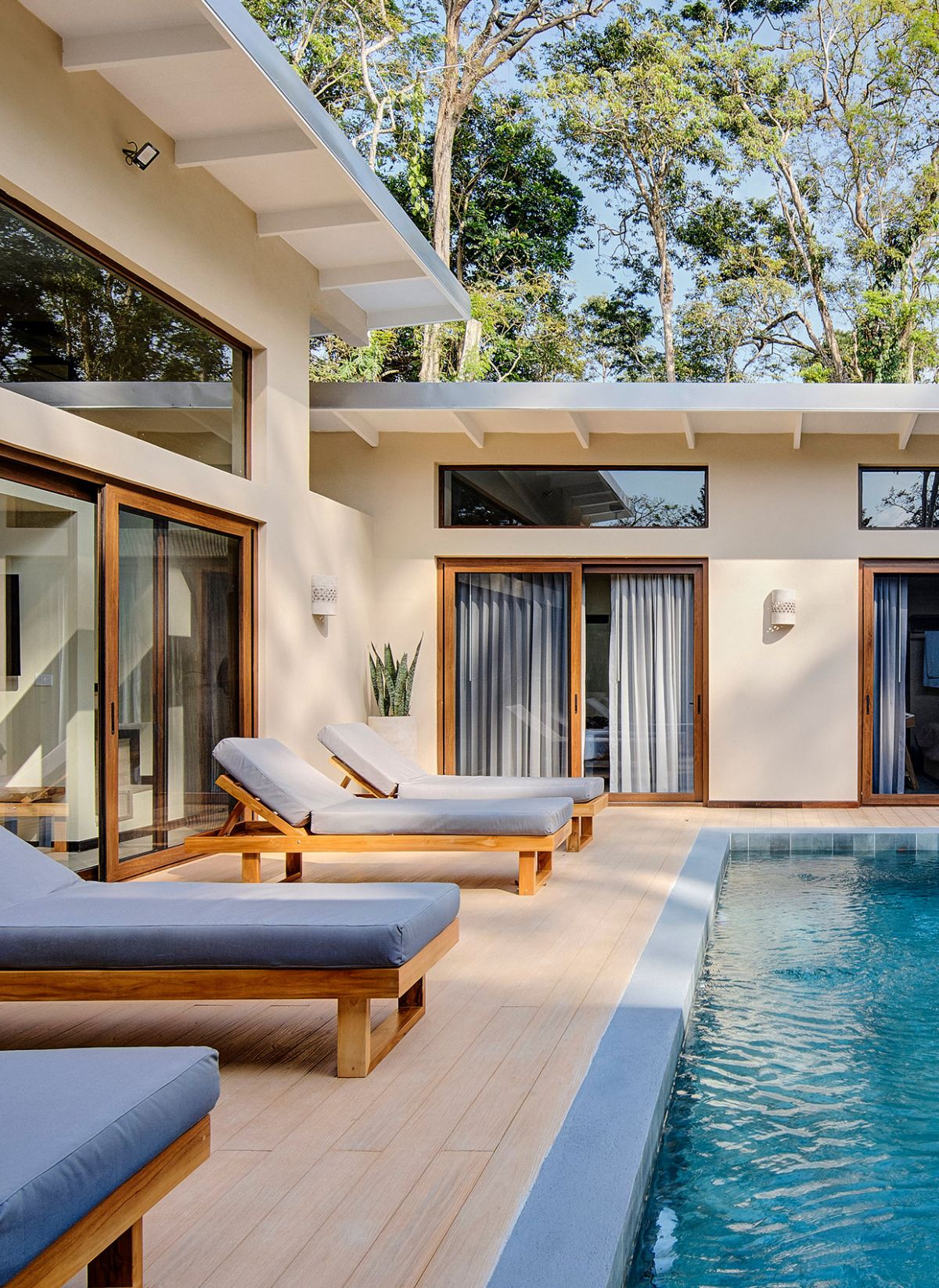 Sun loungers in front of the crystal-clear water of the outdoor pool